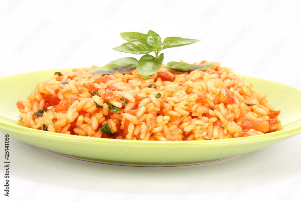 Risotto with tomatoes on a green plate decorated with basil Risotto with tomatoes on a green plate decorated with basil