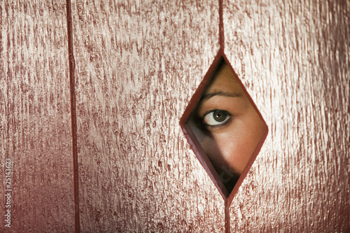 Woman Looking Through a Hole in the Wall