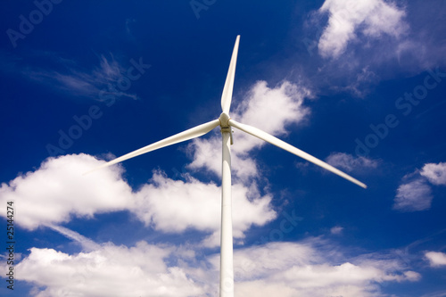 Windmill against a blue sky and clouds, alternative energy sourc photo