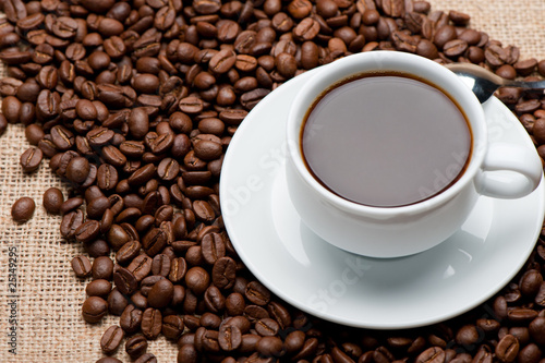 Cup of coffee on coffee grains