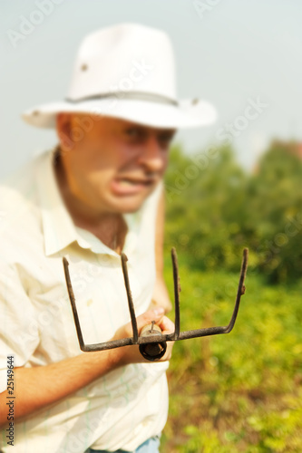 Fototapet Farmer holding pitchfork