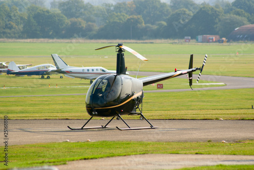Black Robinson R-22 helicopter in the parking