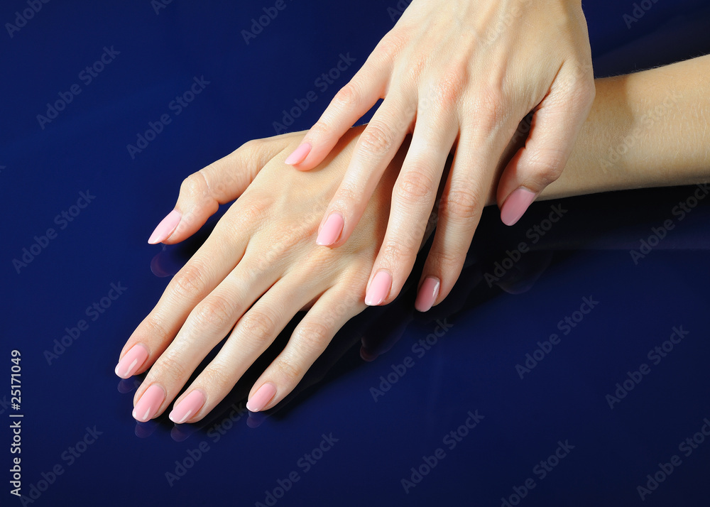 Beautiful hands with perfect nail pink manicure. isolated on blu