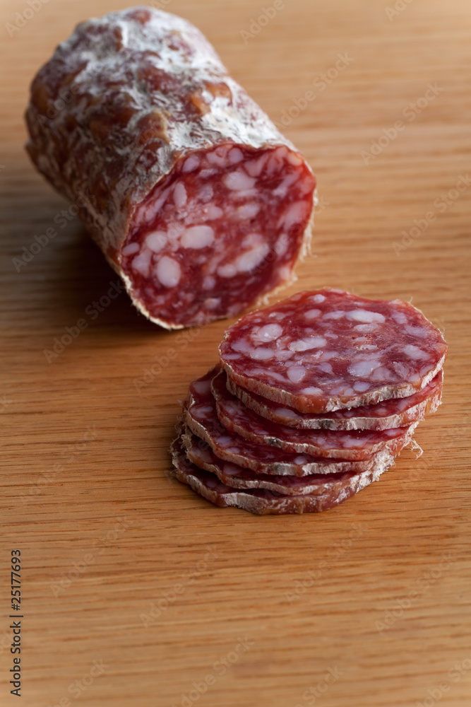 Scheiben einer Salami auf einem Tisch aus Eichenholz Scheiben einer Salami auf einem Tisch aus Eichenholz