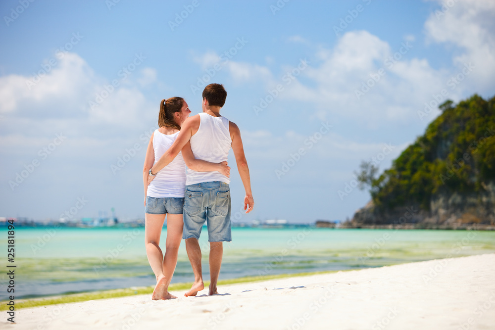 Romantic couple walking along tropical beach Romantic couple walking along tropical beach