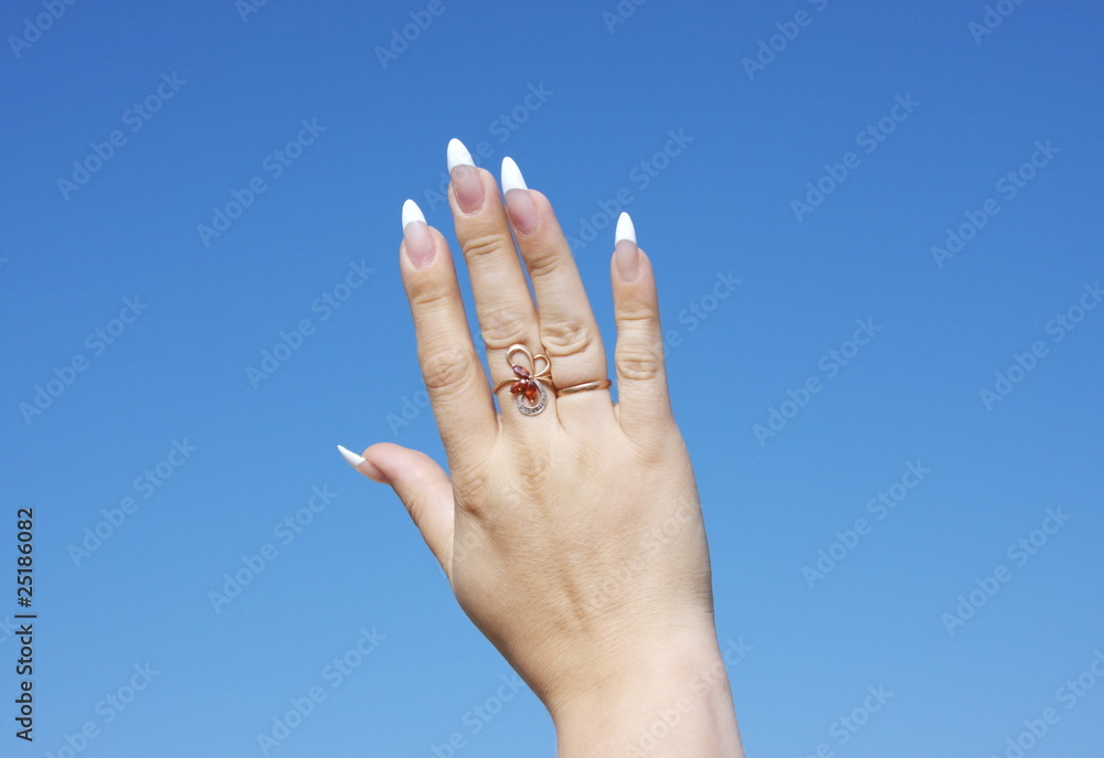 beautiful woman hand on a background blue sky beautiful woman hand on a background blue sky