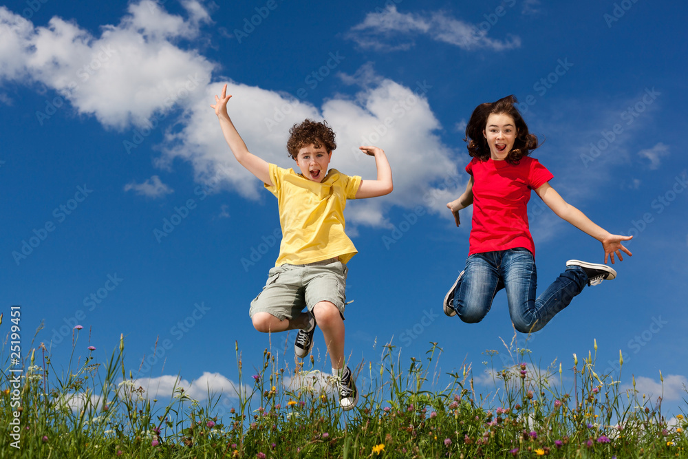 Girl and boy jumping, running against blue sky Girl and boy jumping, running against blue sky