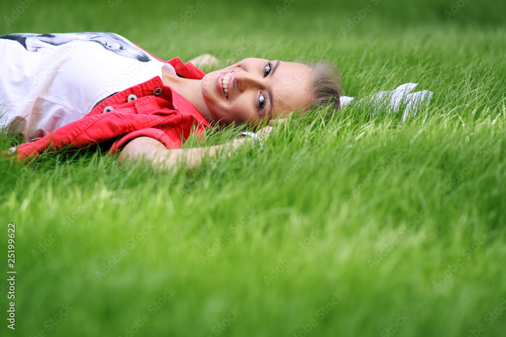 Cute young female lying on grass field at the park Cute young female lying on grass field at the park