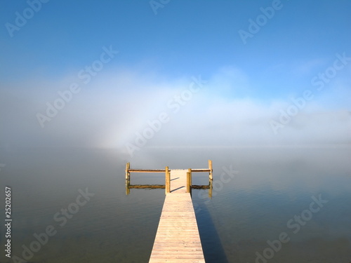 Leerer Steg und Nebel am See photo