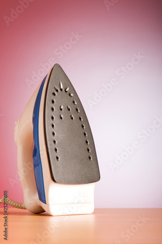 Modern electric iron against the colorful background