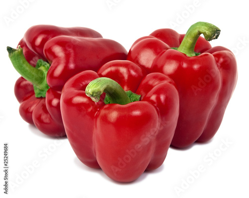 Three red peppers closeup on white background .