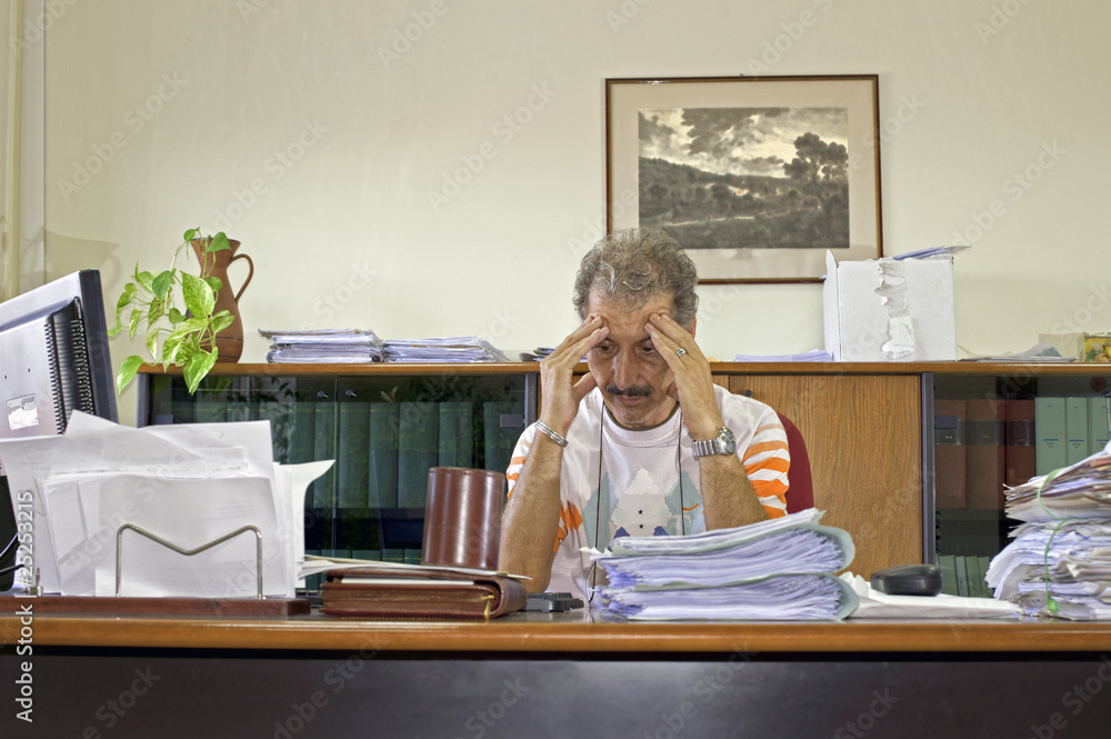 Discouraged manager man at his desk in the office Discouraged manager man at his desk in the office