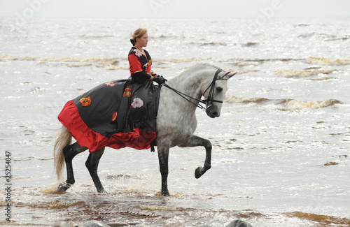 Woman riding horse in sea