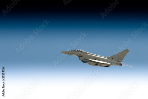 military fighter jet in a gradient blue sky photo