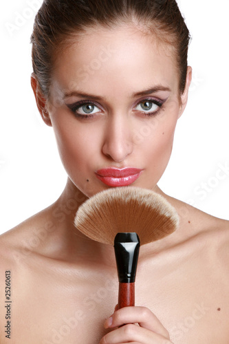 Beautiful young woman with a make-up brush.
