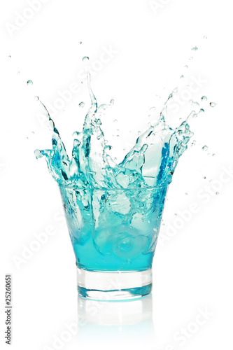 Glass with splashing blue drink
