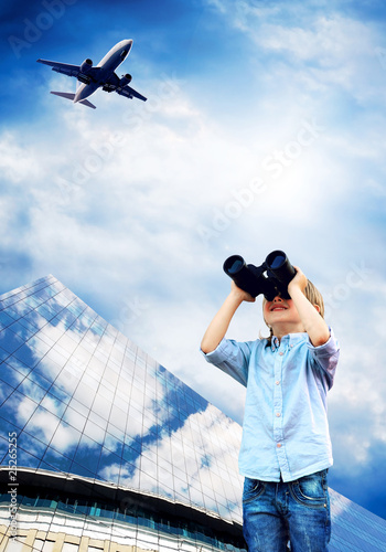 Young boy watch in the field-glass under sky