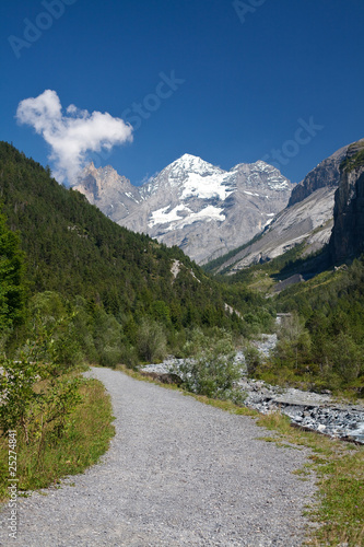 mountain path with snowed peaks at background