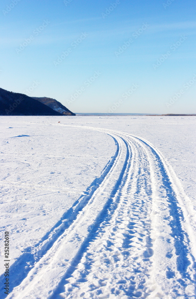 Snowmobile track mark on the snow against mountains