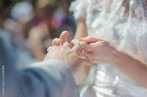 Bride putting a ring on groom's finger © MNStudio