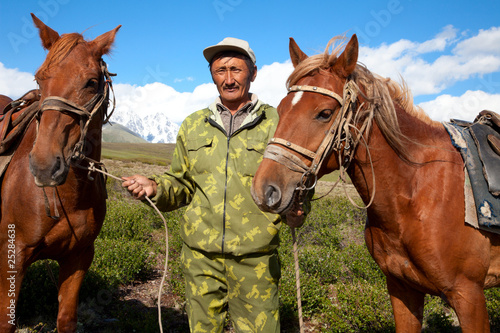 Asian man holding two horses © Hunta
