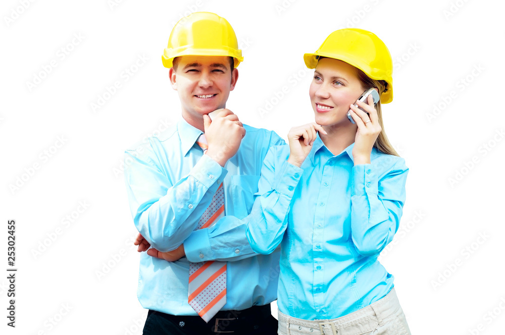 Young architects wearing a protective helmet standing on the bui Young architects wearing a protective helmet standing on the bui