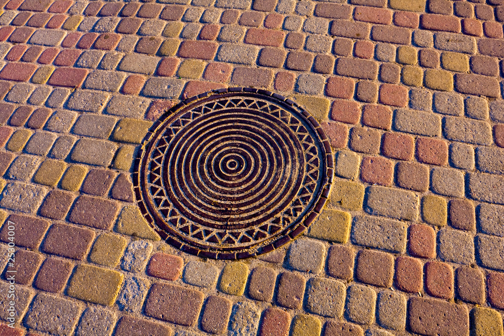 Manhole cover on pavement Manhole cover on pavement