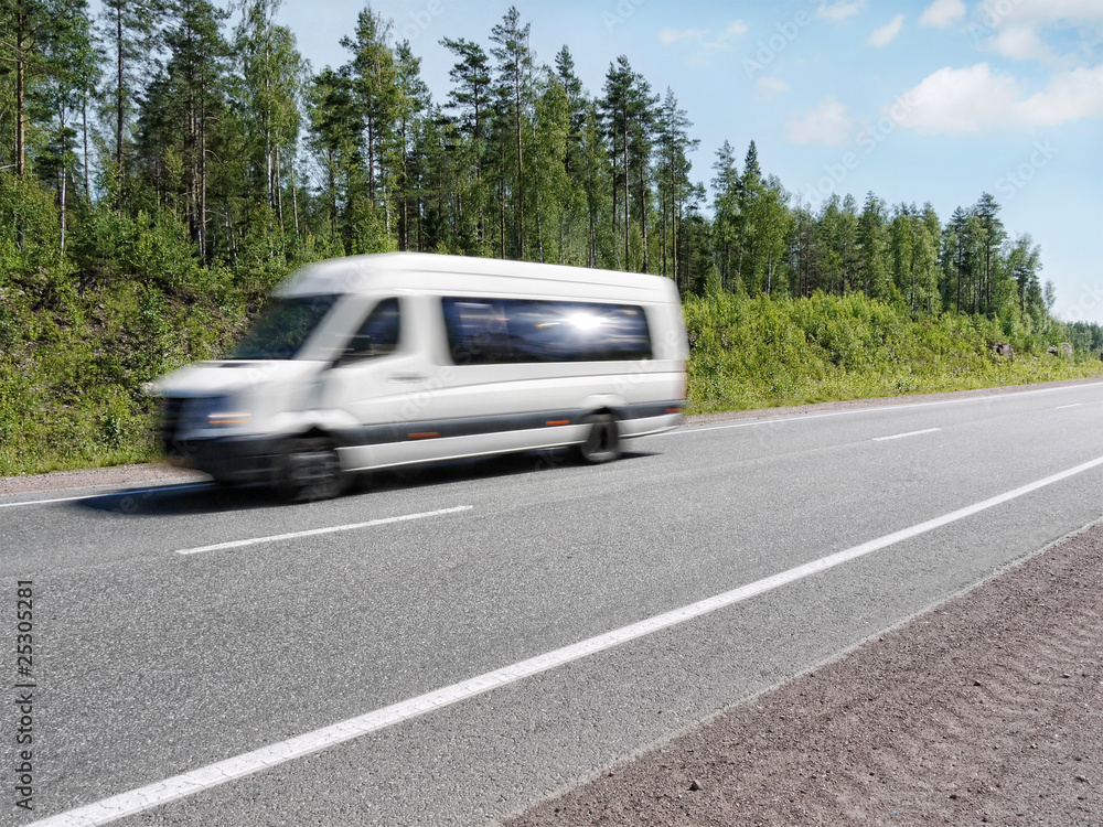 white mini bus speeding on country highway, motion blur
