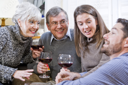 Senior couple, adult children talking and drinking