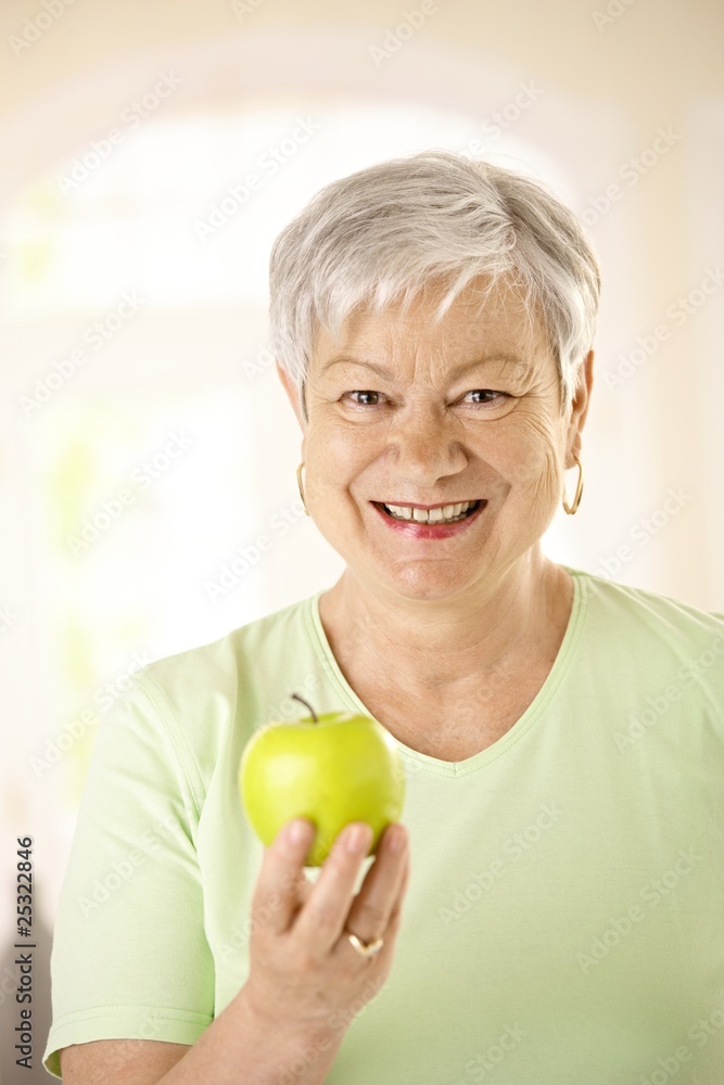 Healthy senior woman holding apple Healthy senior woman holding apple