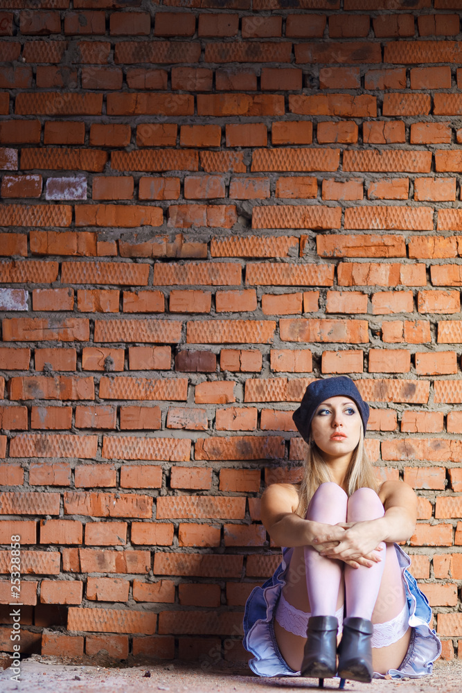 Sexy gorgeous young woman sit near old wall Sexy gorgeous young woman sit near old wall