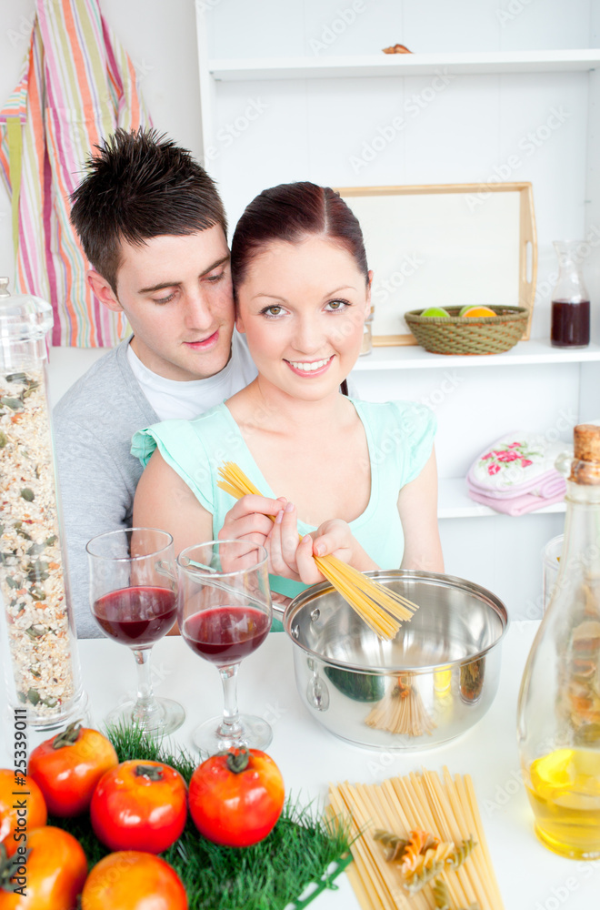 Young couple preparing spaghetti in the kitchen and drinkng wine Young couple preparing spaghetti in the kitchen and drinkng wine