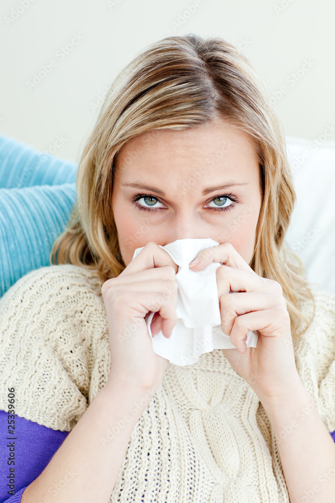 Morbid woman using a tissue sitting on a sofa at home Morbid woman using a tissue sitting on a sofa at home