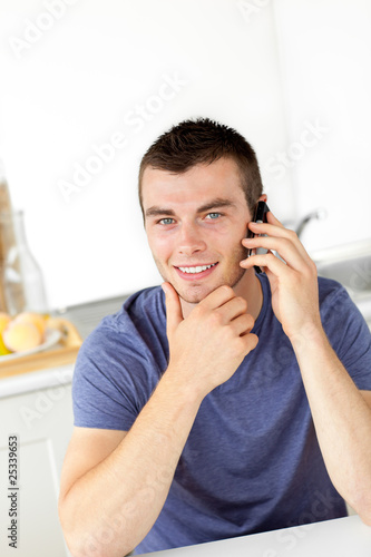 Handsome young man talkng on phone and smiling at the camera