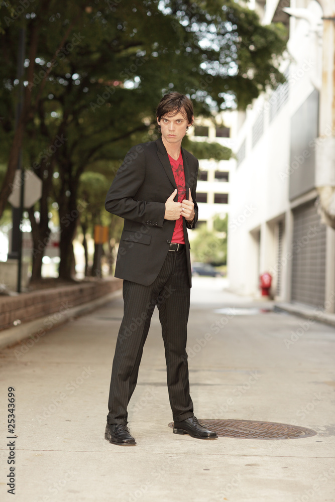 Fashionable young man posing in the alley Fashionable young man posing in the alley