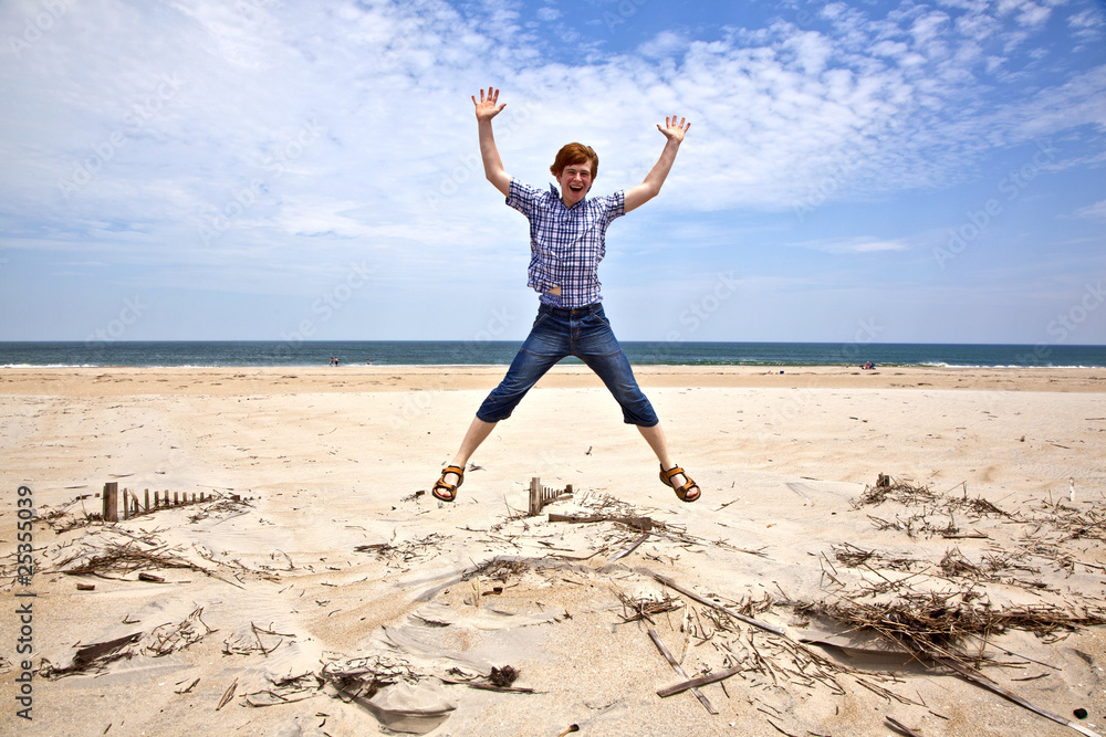 boy enjoys the beautiful beach and jumps boy enjoys the beautiful beach and jumps