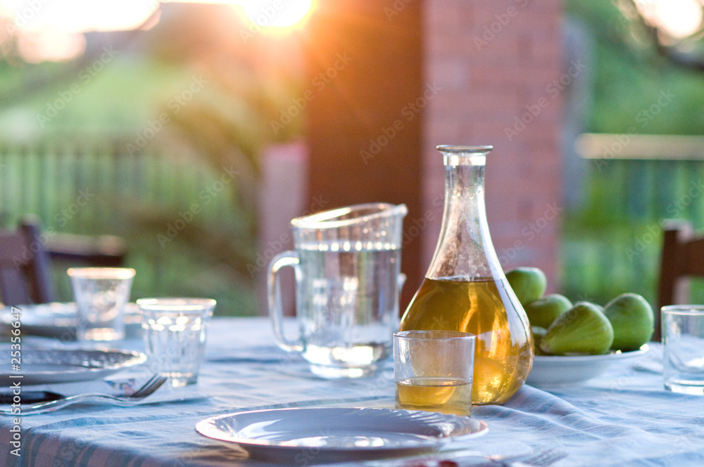 table setting with white wine and fresh figs outside table setting with white wine and fresh figs outside