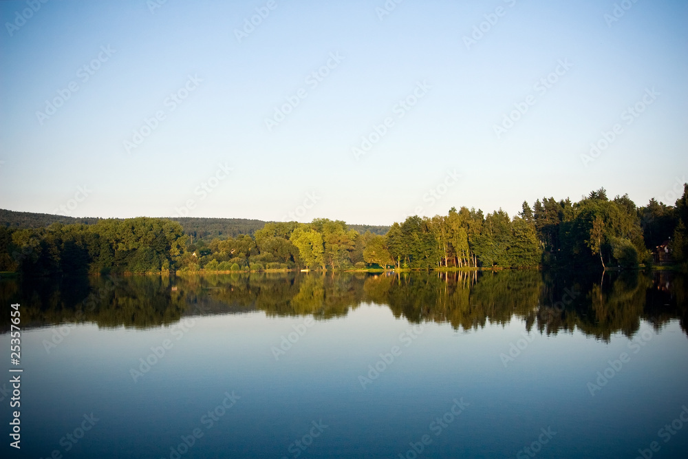 Lake, forest and sky at romantic evening