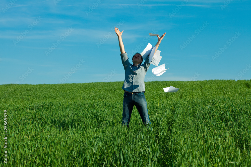 young man throwing a paper in the green field young man throwing a paper in the green field