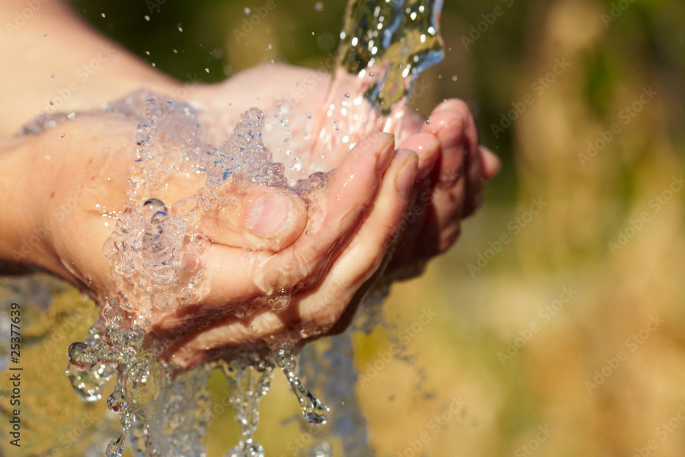 Fototapeta premium Woman's hands with water splash
