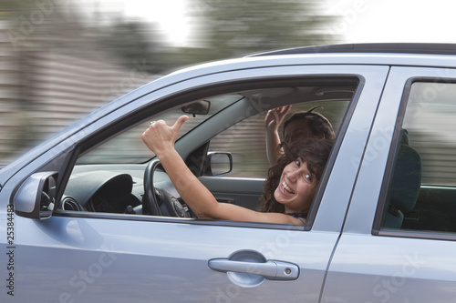 happy young couple in car, girl with thumb up.