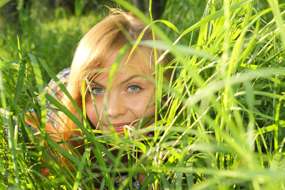 The girl looks through a grass The girl looks through a grass