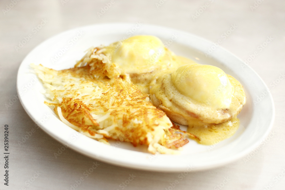 Eggs benedict and hash brown potatoes