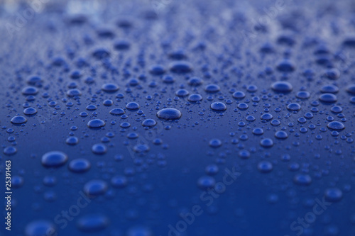 rain drops on a blue car body, shallow focus