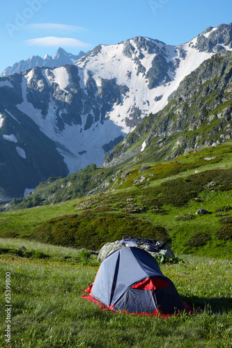 Mountaneers tent on meadow in the mountains photo