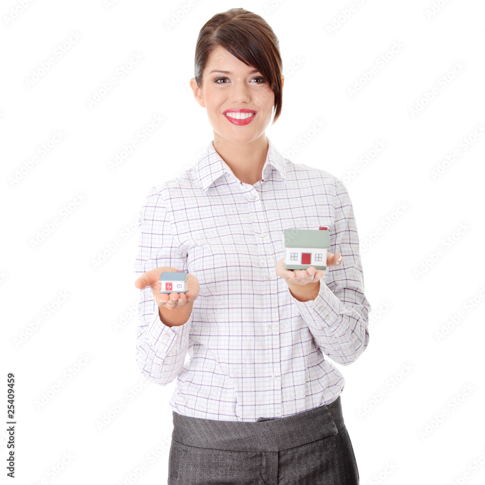 Young businesswoman holding two house models Young businesswoman holding two house models