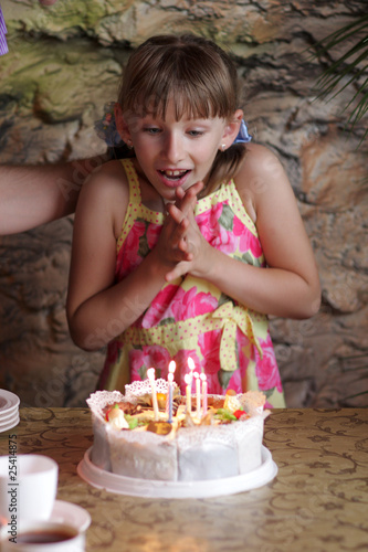 Excited girl looks on cake