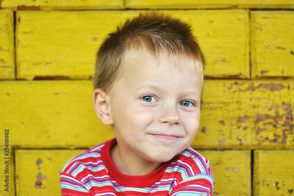 smiling boy in the background of yellow wall smiling boy in the background of yellow wall