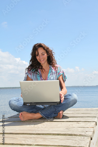 Woman using laptop computer on a pontoon