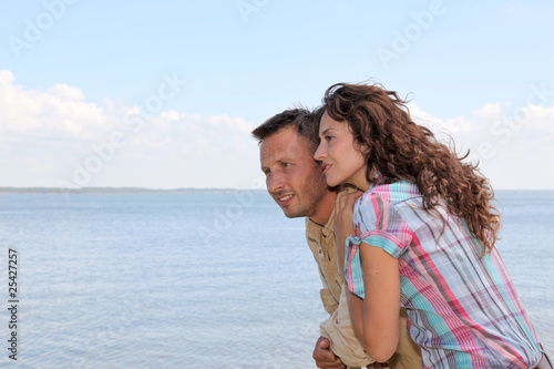 Closeup of loving couple standing on a pontoon by a lake